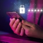 Hand holding a smartphone with a glowing padlock and masked password symbols, illustrating how passwords get stolen and how to protect them.